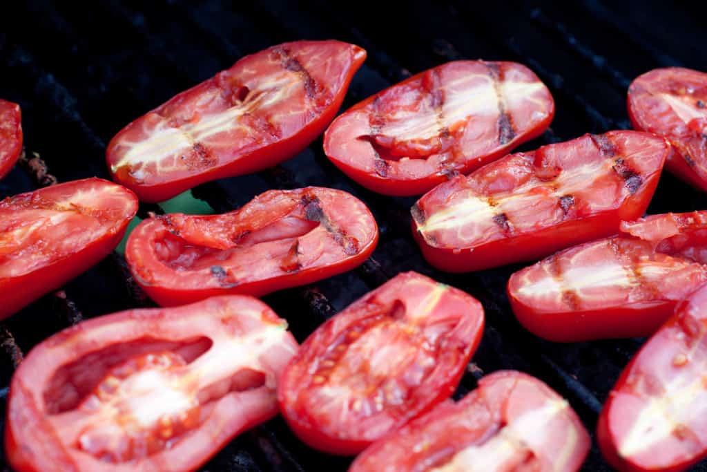 halved tomatoes with grill marks on a grill.