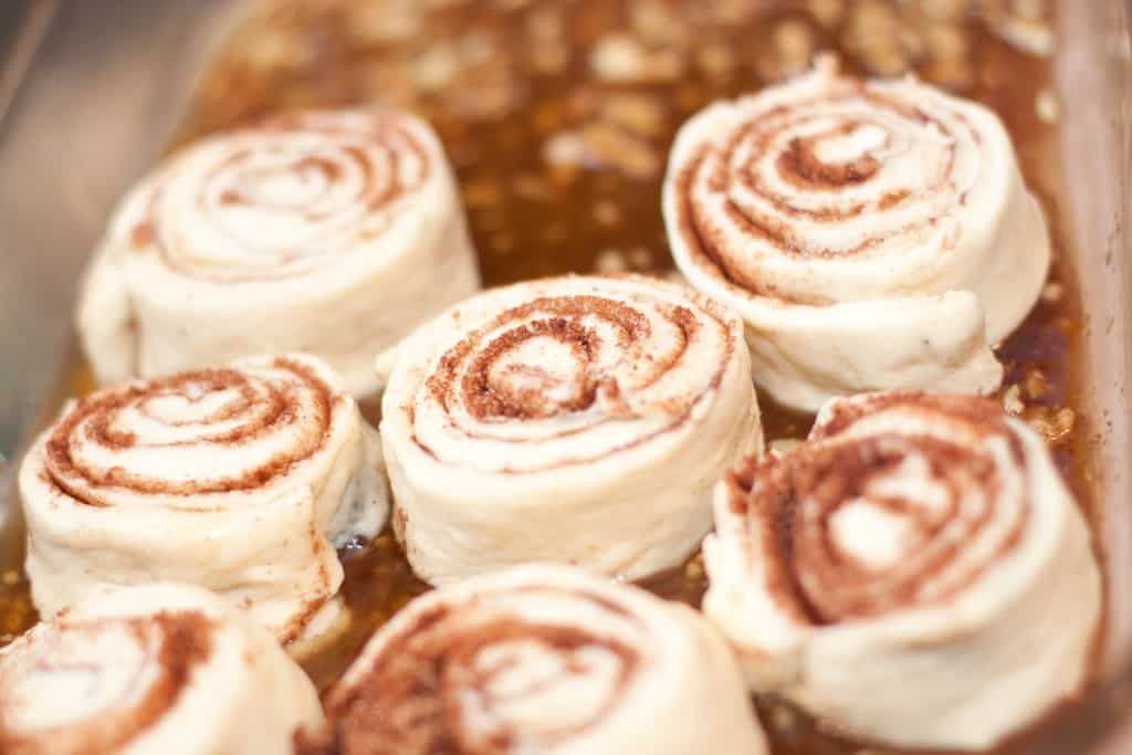 uncooked cinnamon rolls in a glass dish.