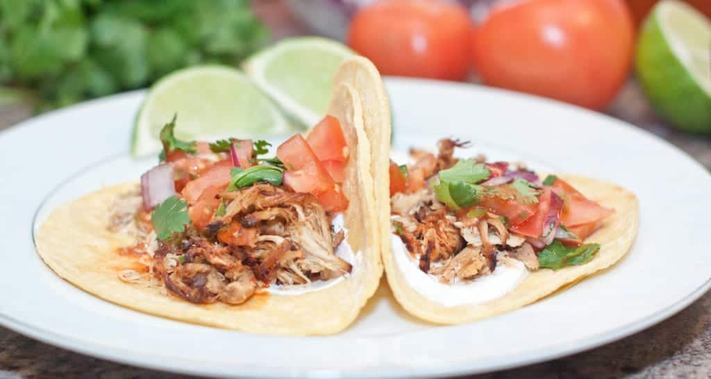 two chicken tacos on a plate.