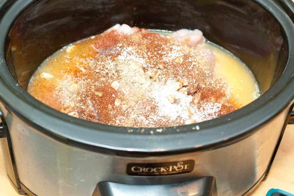 meat with juice and spices in a crock pot.