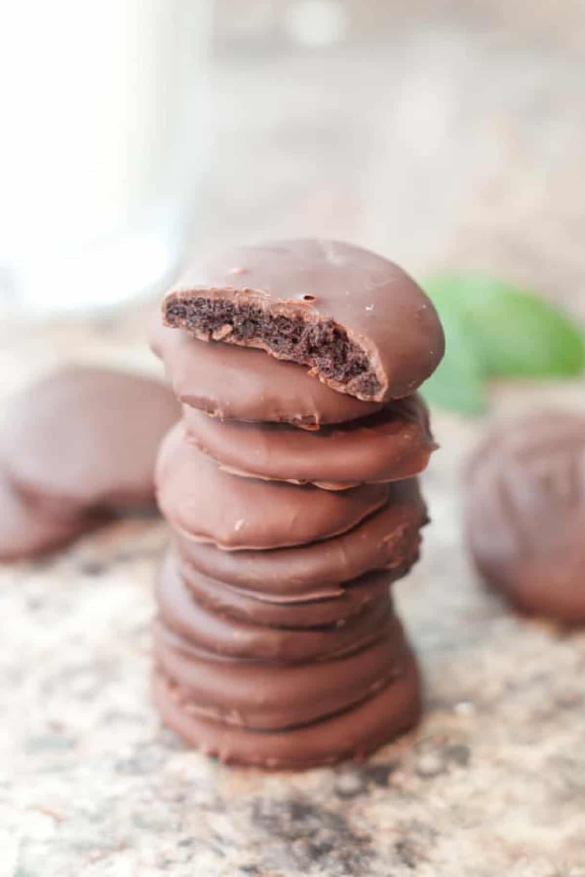 a stack of thin mint cookies with one with a bite taken out.