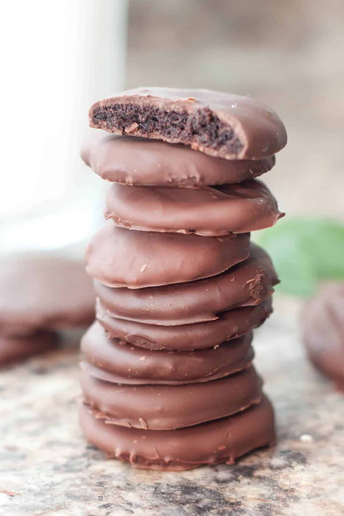 a stack of thin mint cookies with one with a bite taken out. 