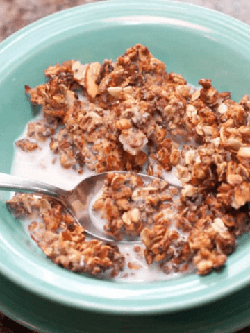 a bowl of cereal with milk and a spoon.