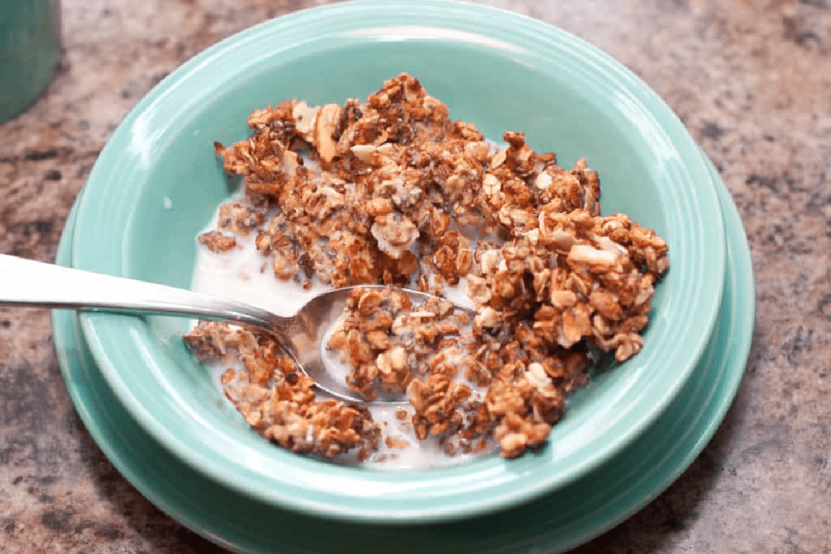 a bowl of cereal with milk and a spoon.