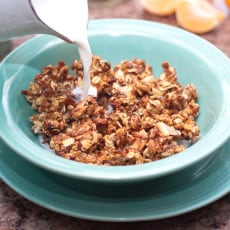 milk being poured into a bowl of cereal.