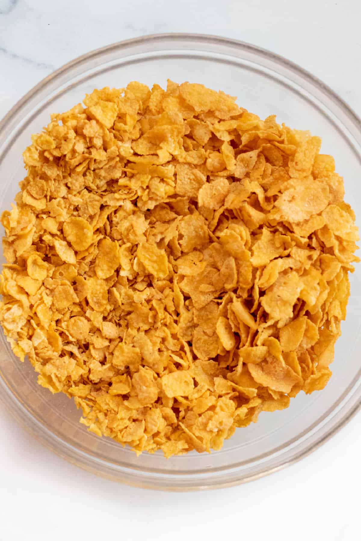 a bowl of cornflakes with some crushed and some whole.