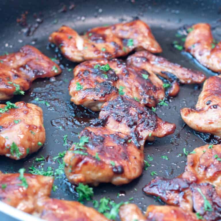 a pan of glazed cooked chicken thighs.