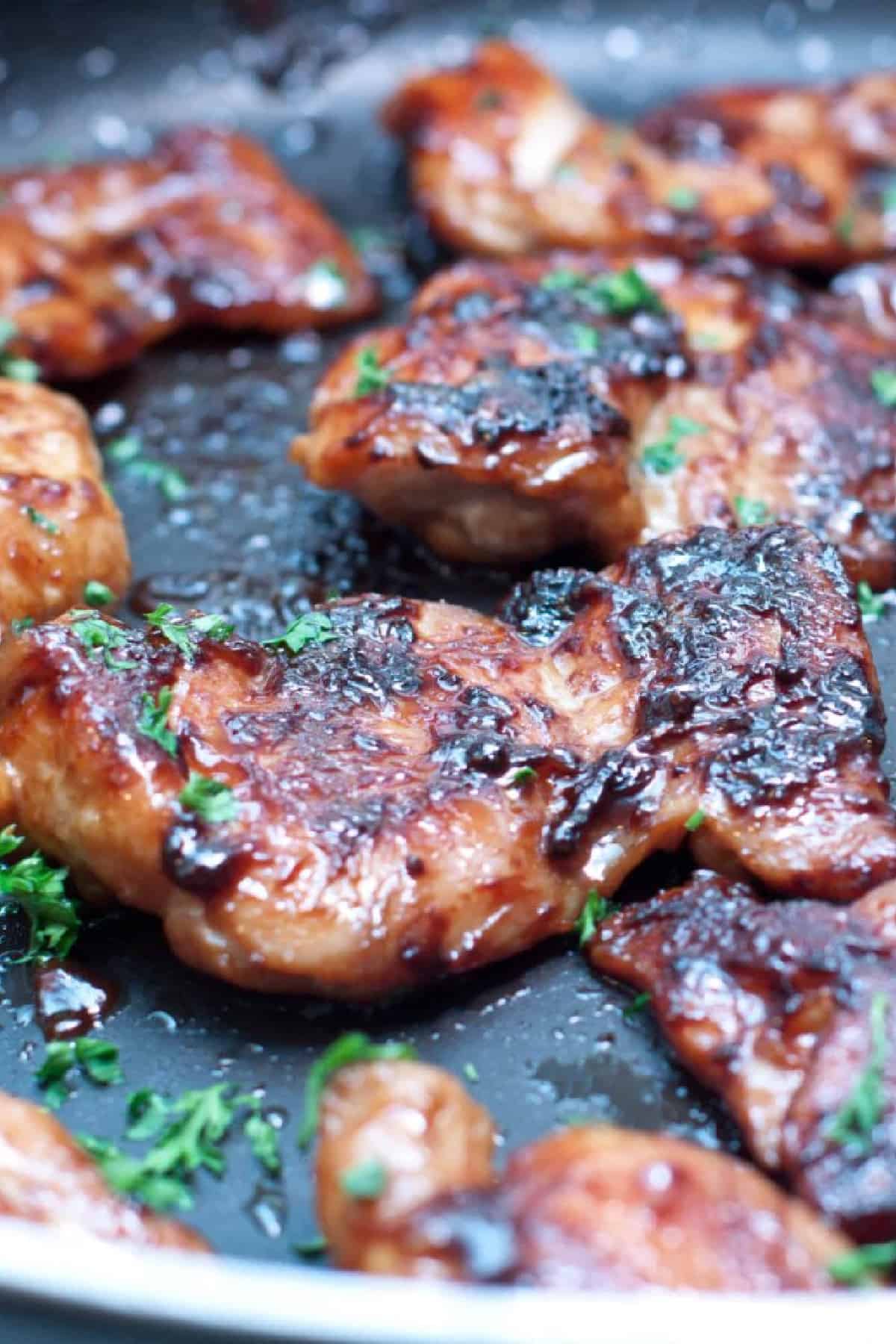 a pan of glazed cooked chicken thighs.