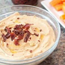 hummus in bowl with sundried tomatoes on top