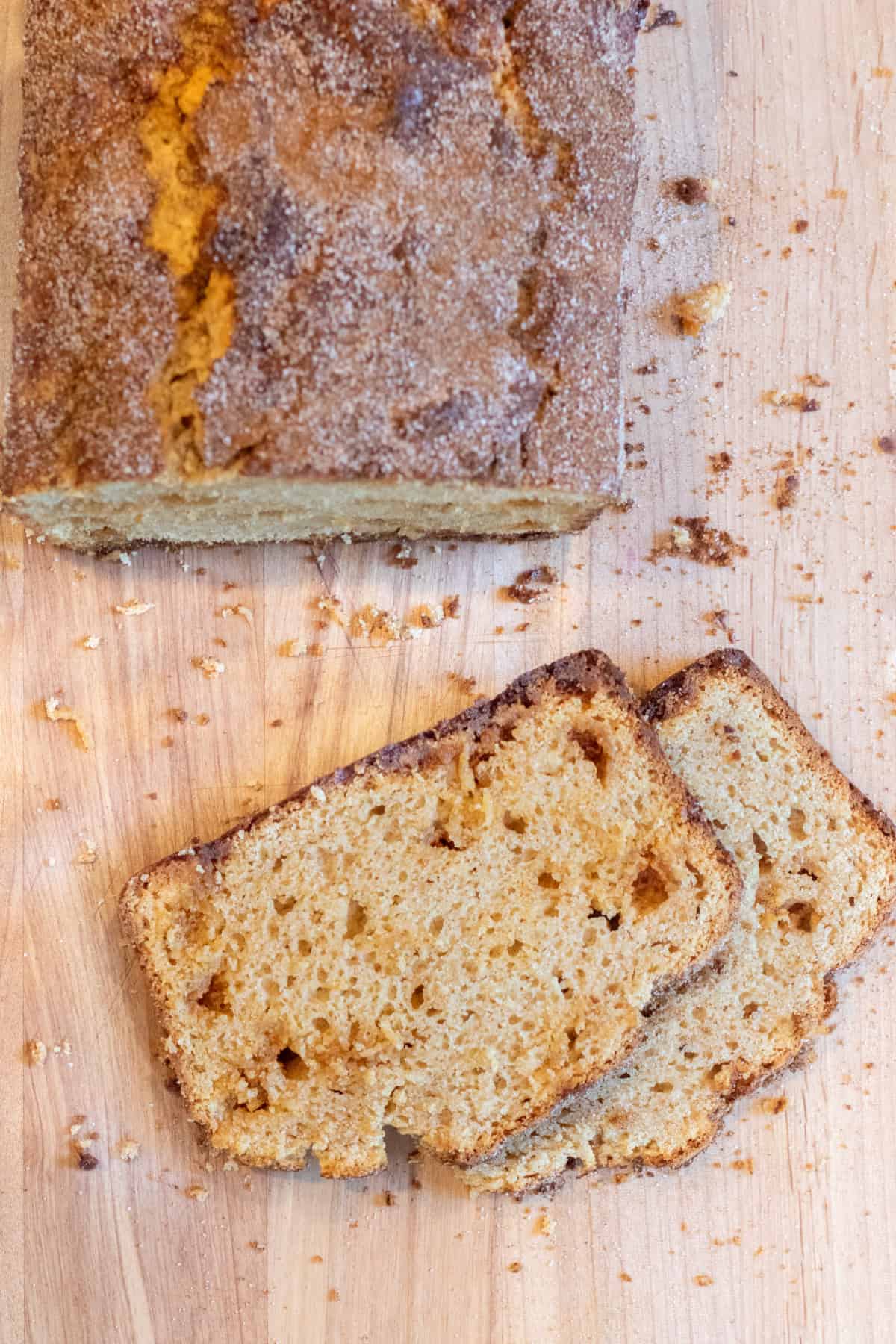 an overhead of snickerdoodle bread with two slices on a cutting board.