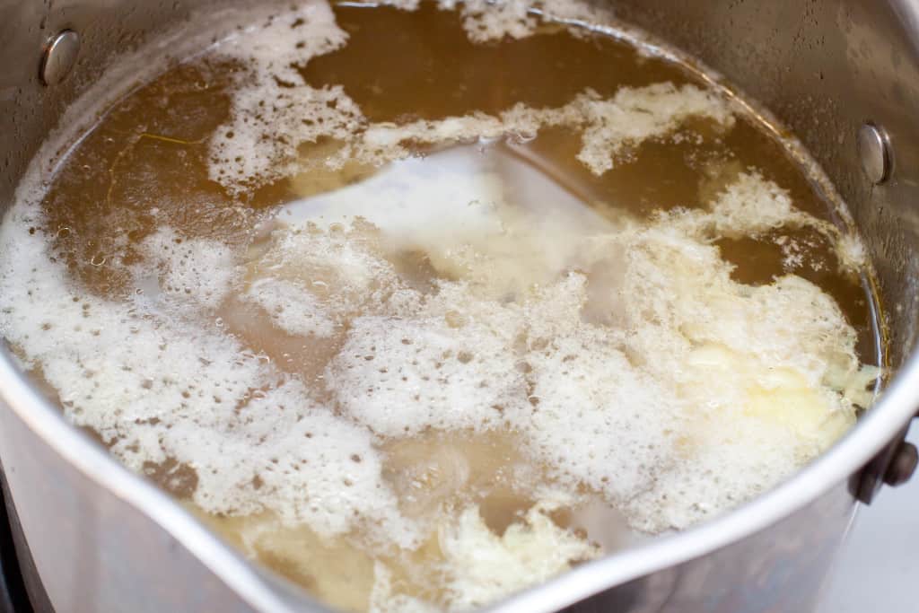 stock being clarified in a stock pot.