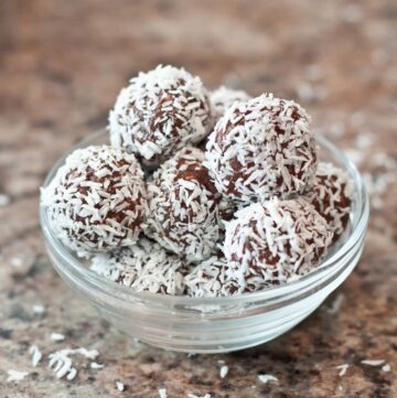 rolled bliss balls coated with coconut in a bowl