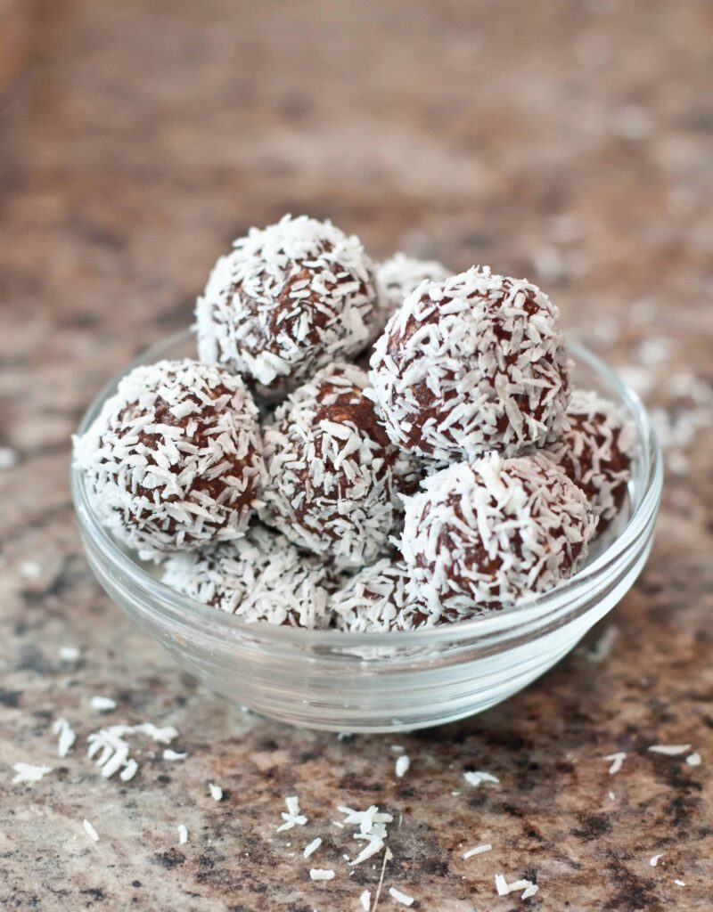 a bowl of coconut covered chocolate balls 
