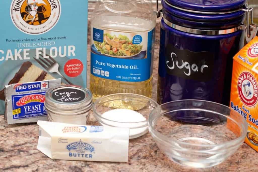 cake flour, sugar, oil, baking soda, butter, salt on a counter.