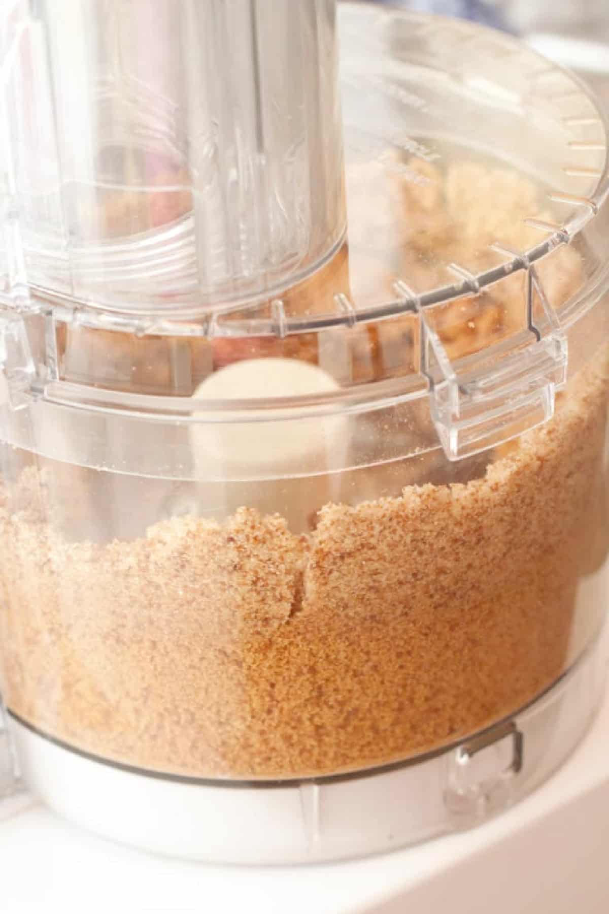 a food processor with brown sugar blending in it.