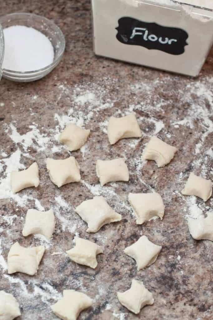 uncooked homemade gnocchi on a floured counter.