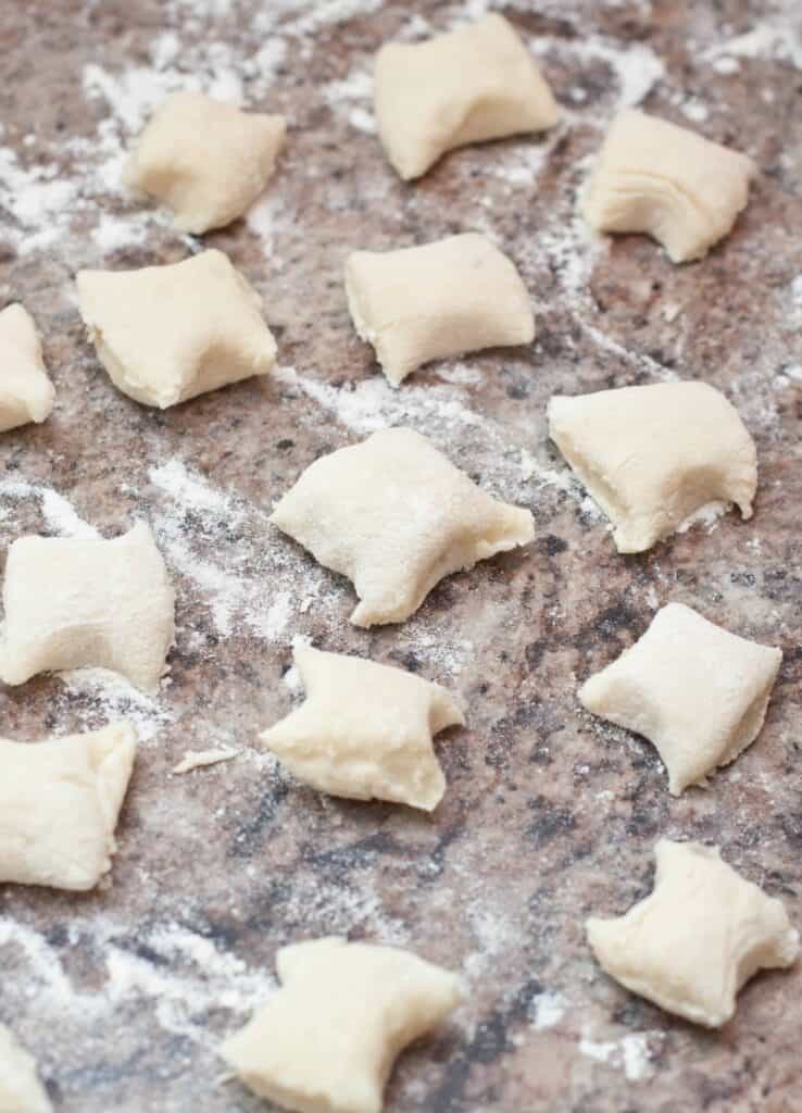 uncooked homemade gnocchi on a floured counter.