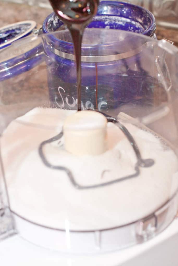 sugar in a food processor with molasses being poured in