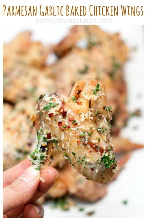 parmesan garlic baked chicken wing held in the air