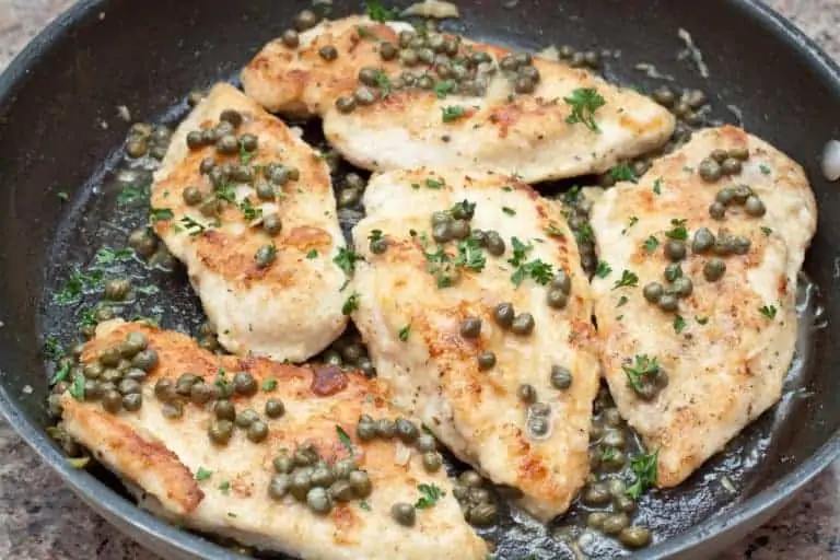 a pan of cooked chicken topped with capers