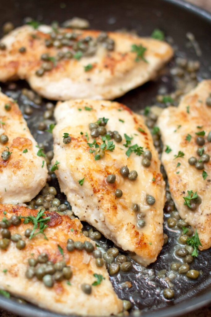 a pan of cooked chicken topped with capers
