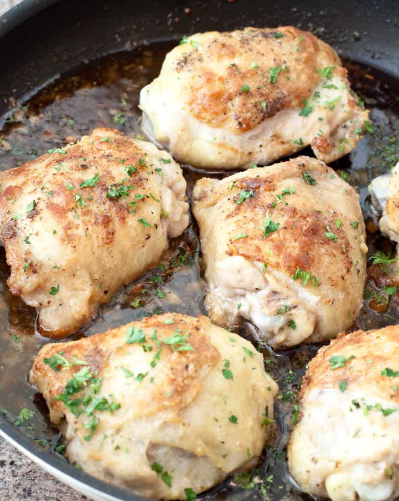 skin on baked chicken thighs in a pan.