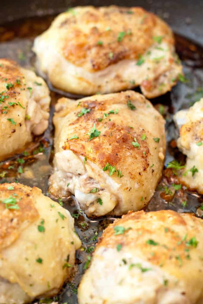 skin on baked chicken thighs in a pan.