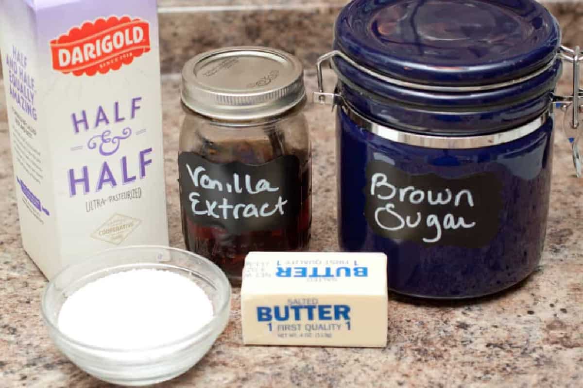 half and half, vanilla extract, salt, butter, and a blue canister labeled brown sugar on a counter.