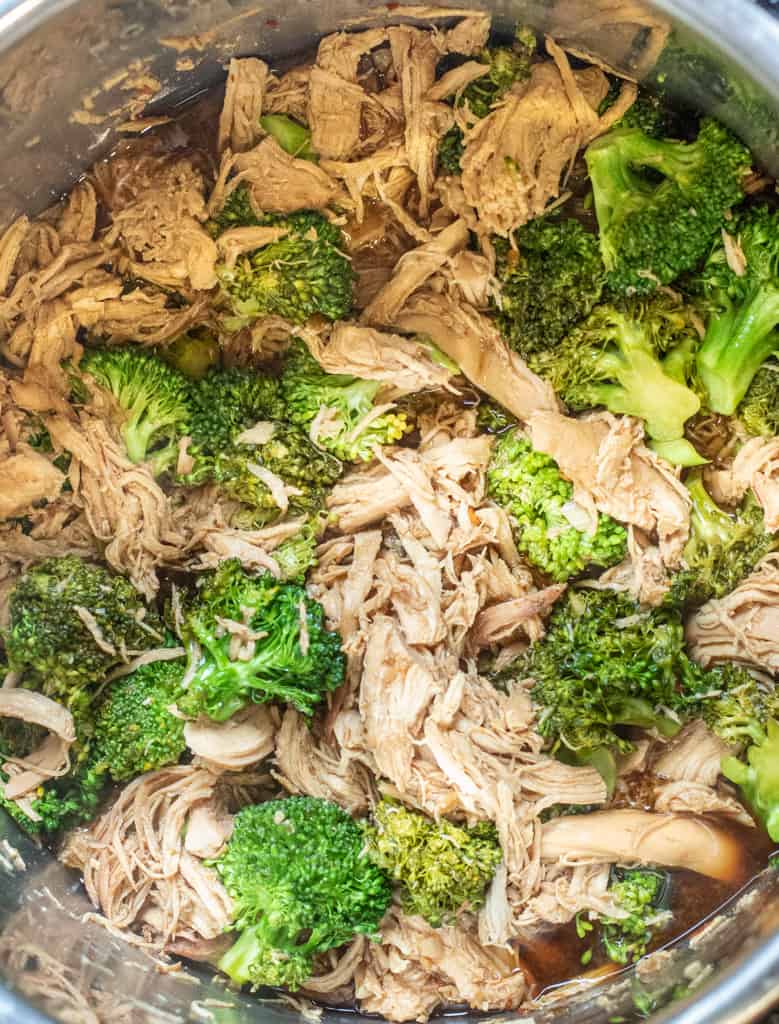 shredded chicken and broccoli in a pot.