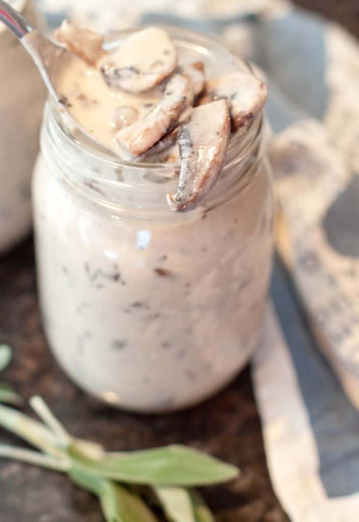 an open mason jar with a spoon scooping out some mushroom soup.