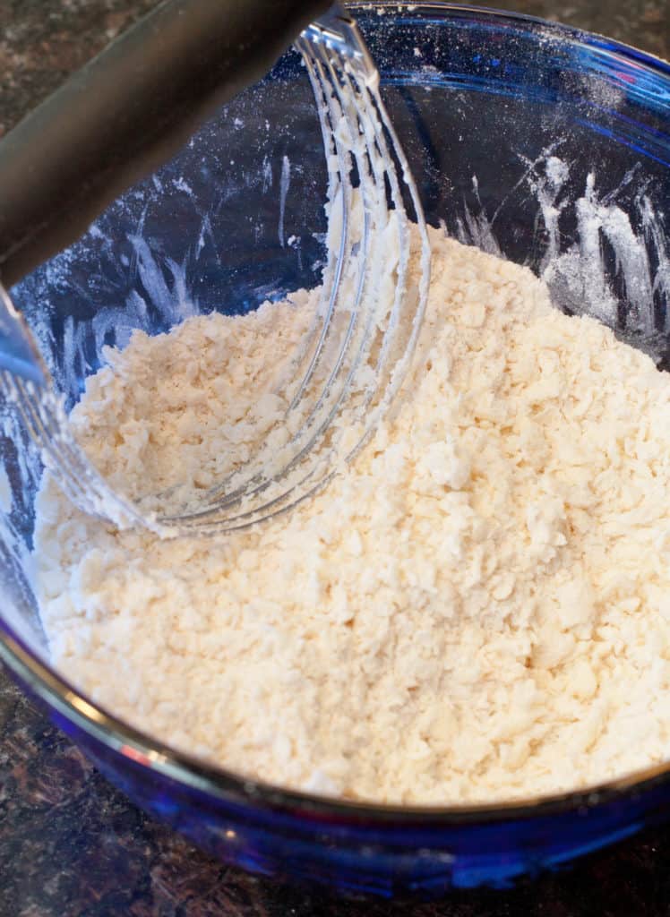 a bowl with butter cut into flour and a pastry cutter.