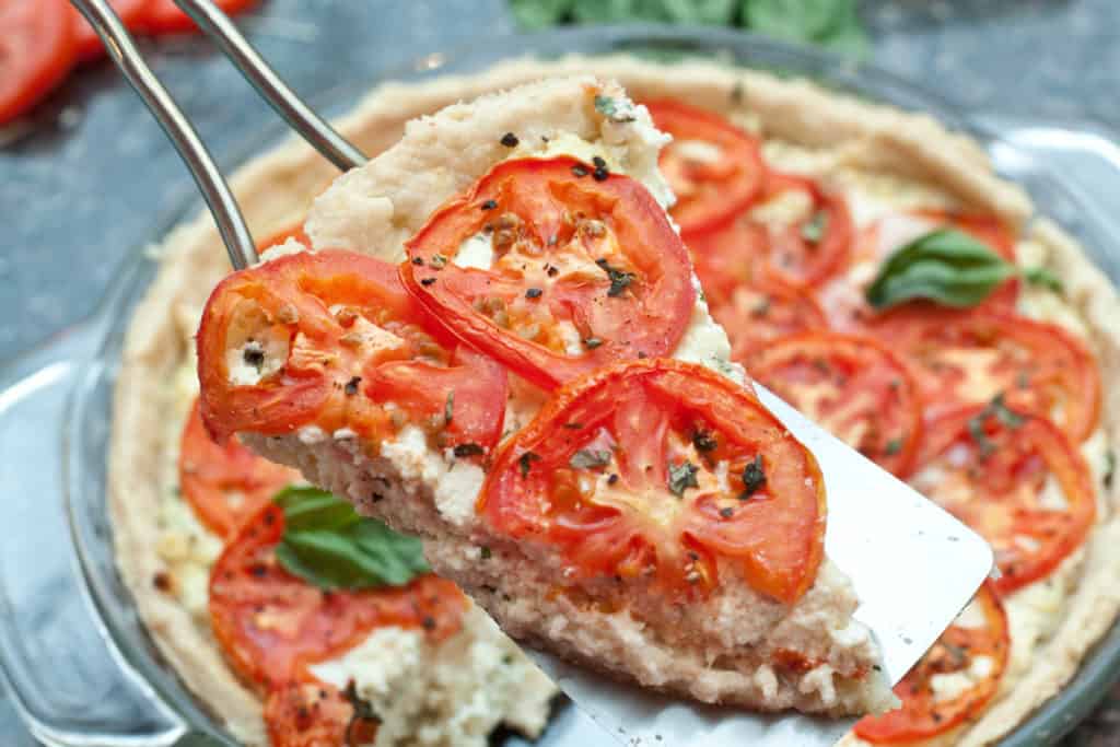 a piece of tomato pie scooped out of the pie.