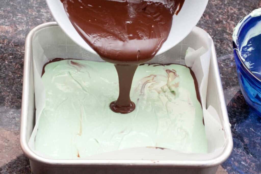chocolate being poured over a mint green filled tray. 
