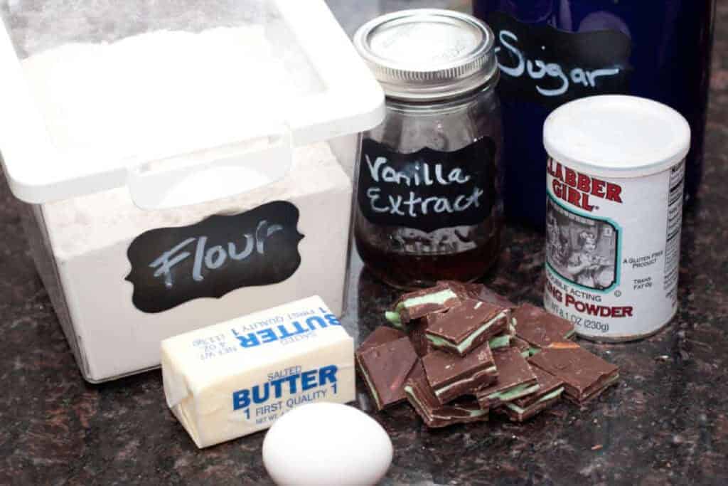 a flour container, butter, egg, andes mints, a container of vanilla extract, baking powder, and container of sugar.