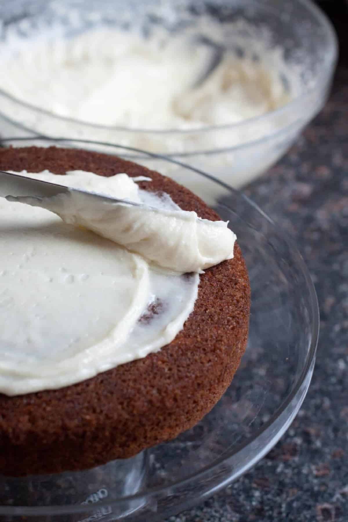 a cake being frosted with a knife.