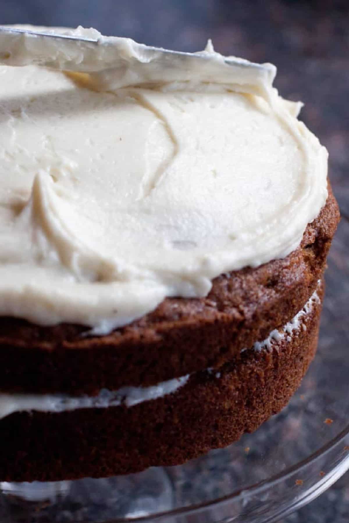 a cake being frosted with a knife.