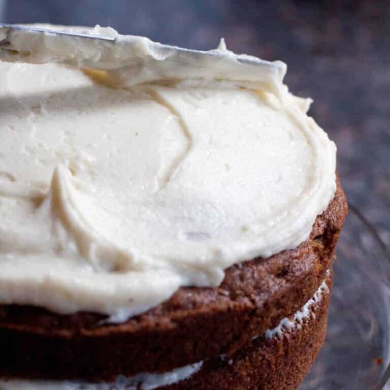 a cake being frosted with a knife.