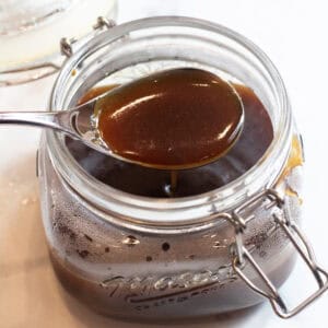a spoon of teriyaki sauce over an open jar of sauce.