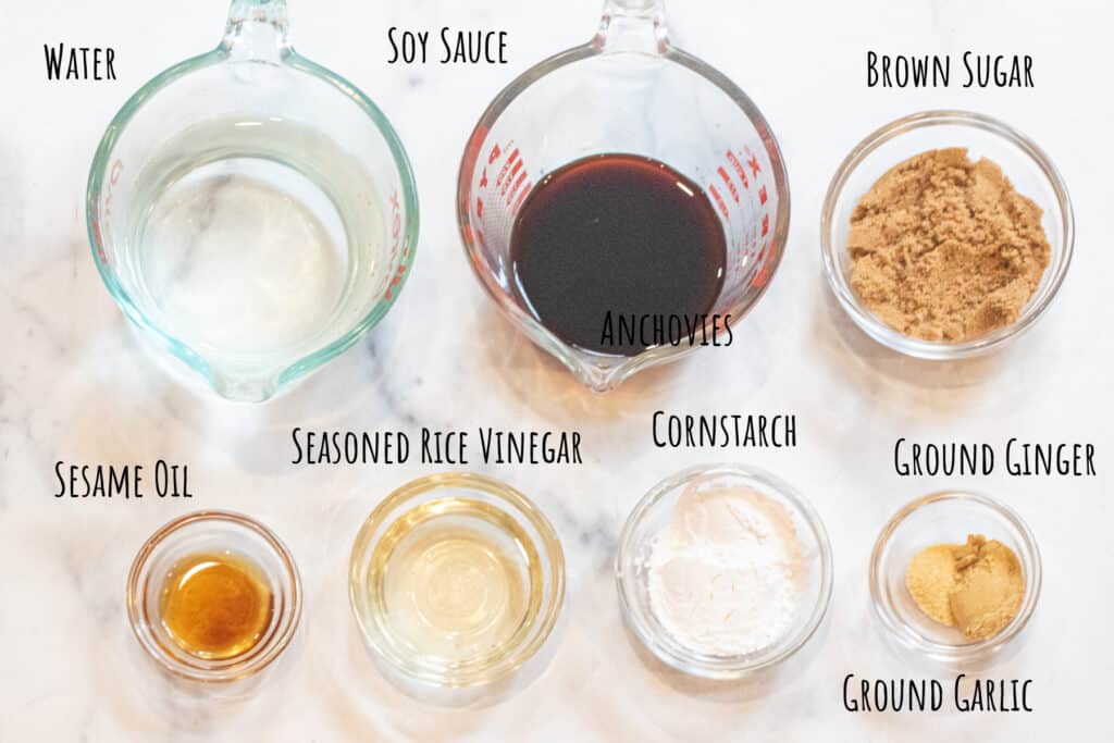 Pyrex and bowls of water, soy sauce, brown sugar, sesame oil, seasoned rice vinegar, cornstarch, and ground ginger and garlic all labeled.