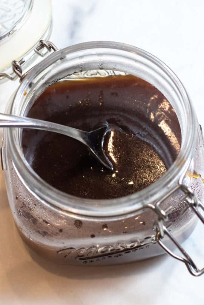 an open jar of teriyaki sauce with a spoon in it.