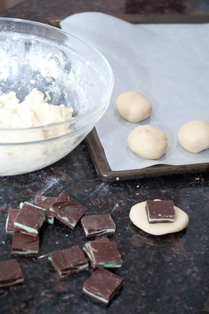 sugar cookies with a andes mints on the inside being formed into cookies balls 