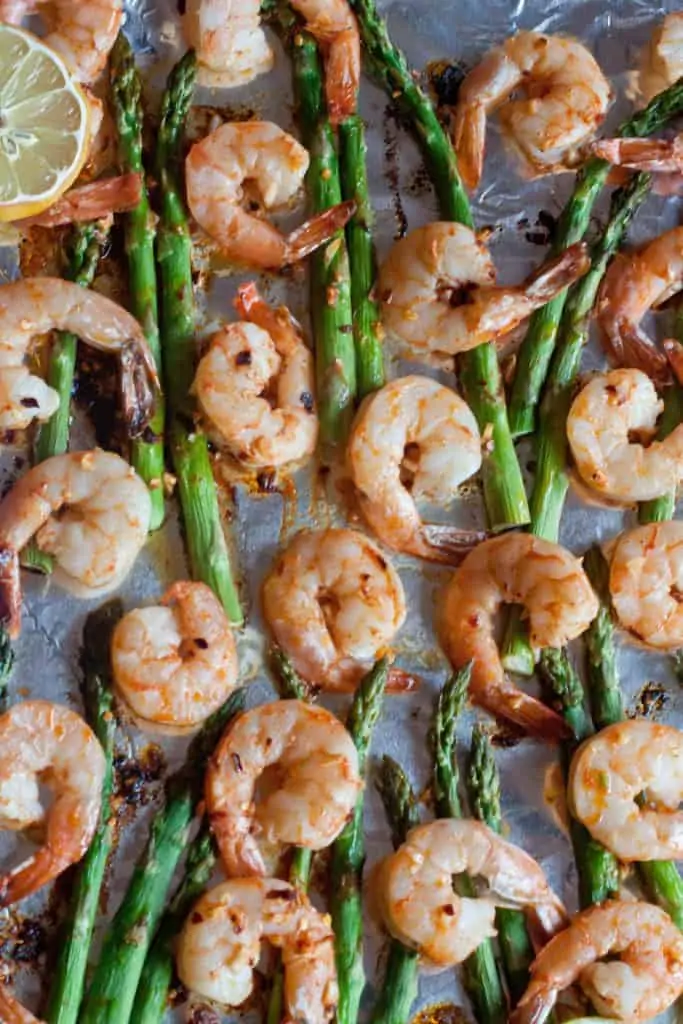 an overhead of cooked shrimp and asparagus.