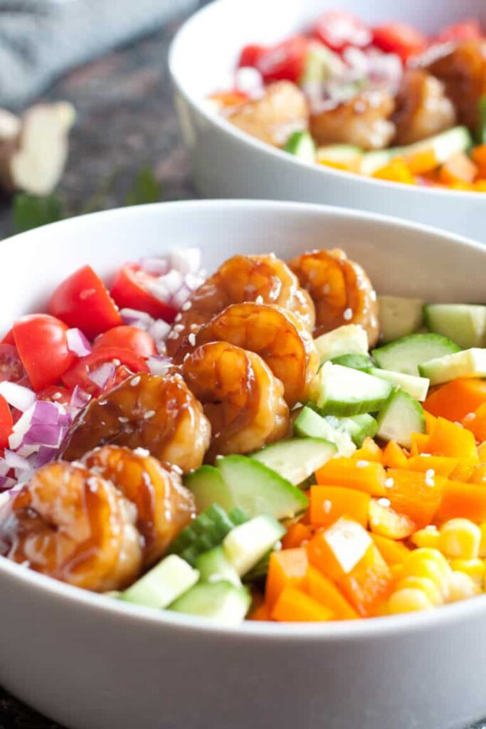 bowl with shrimp and colorful chopped vegetables.