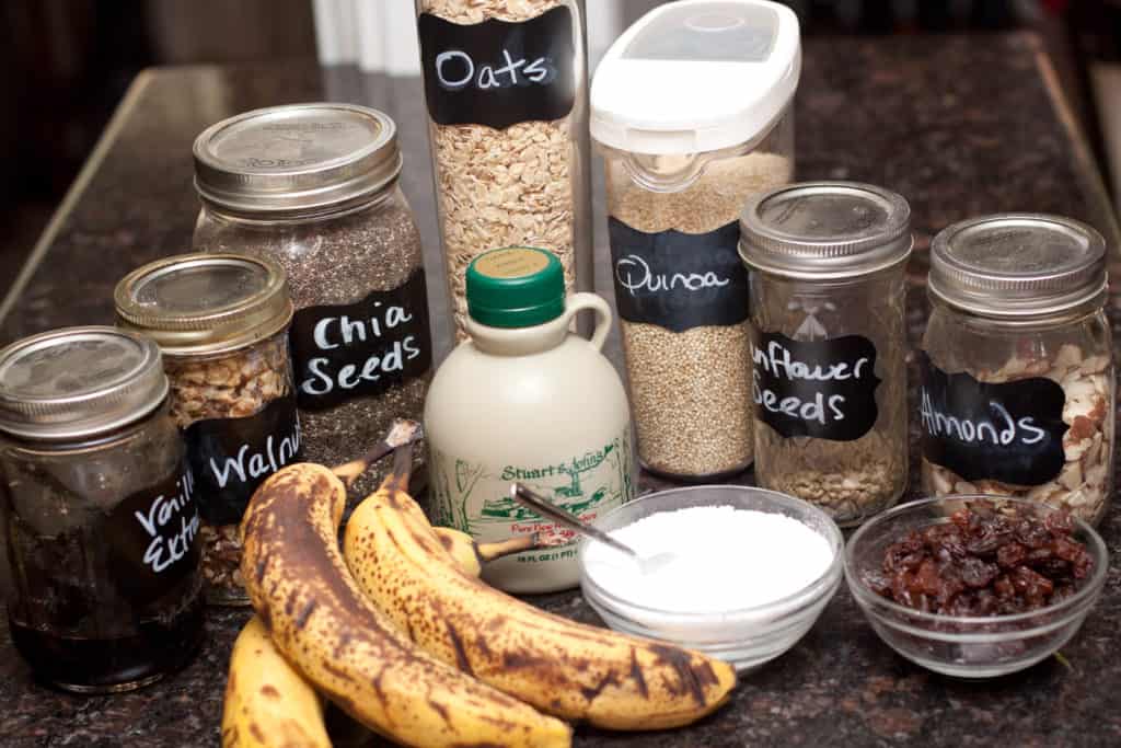 bananas, oats, quinoa, nuts,  salt, maple syrup and raisins on counter