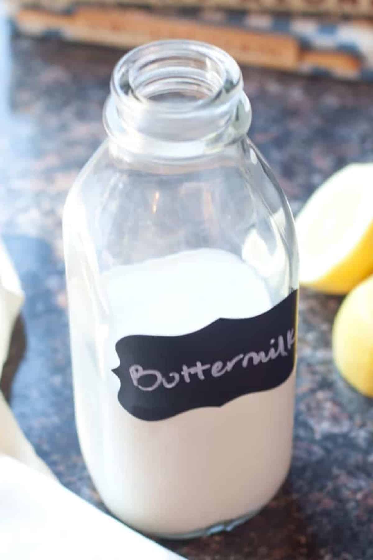 a bottle of labeled buttermilk next to sliced lemons.