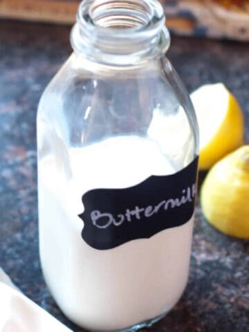 a bottle of labeled buttermilk next to sliced lemons.