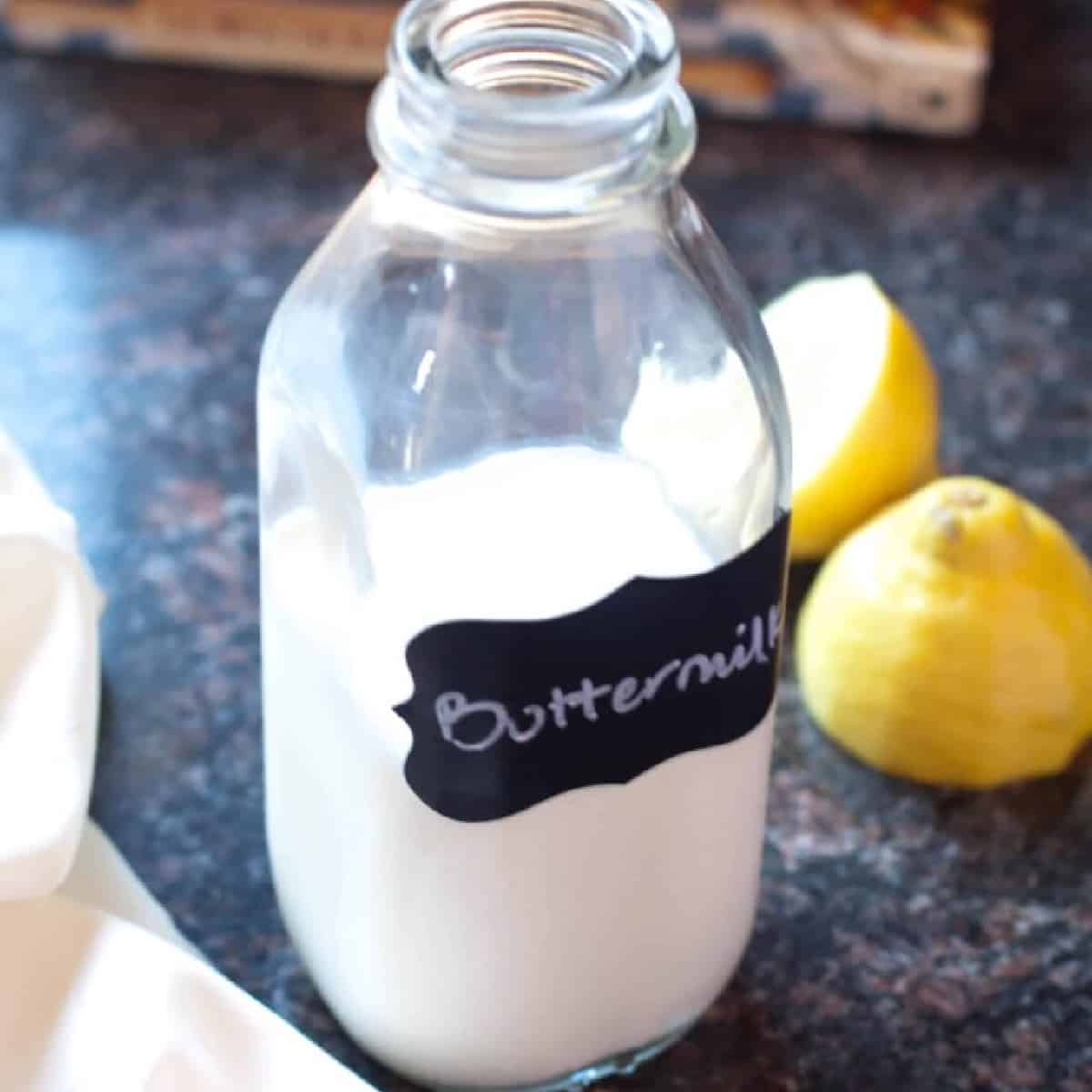 a bottle of labeled buttermilk next to sliced lemons.