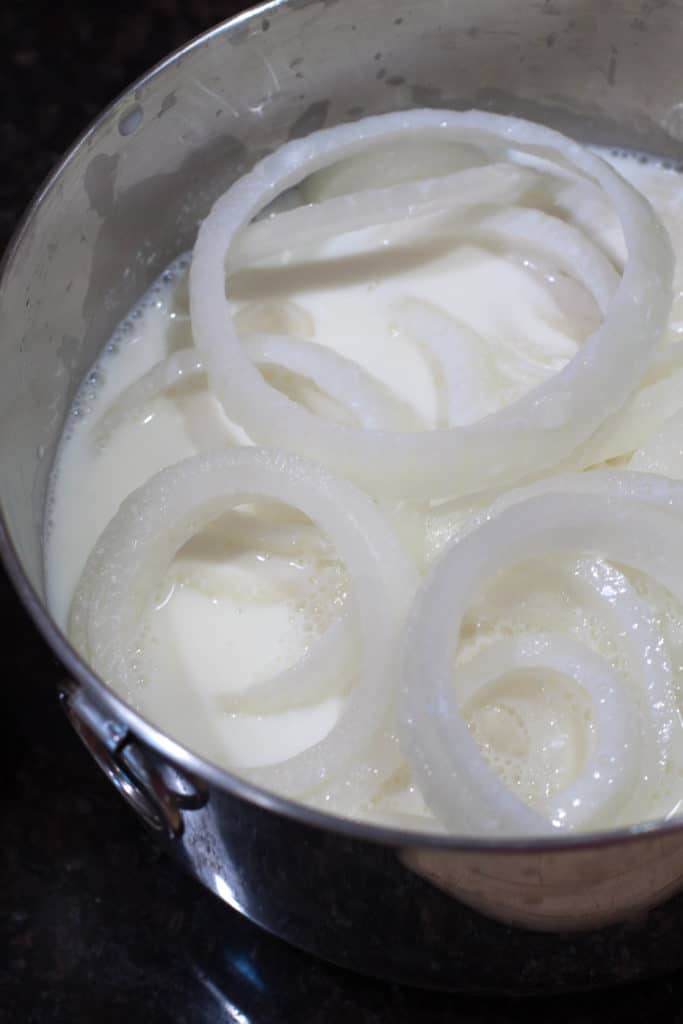 Sliced onions soaking in buttermilk.