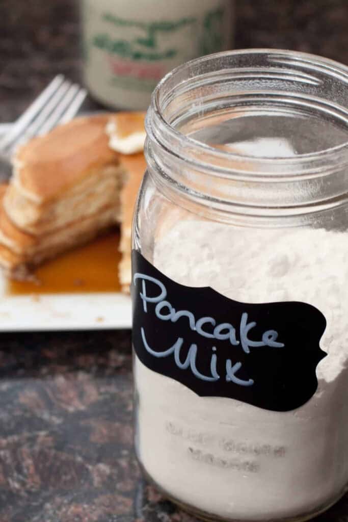 a jar of labeled pancake mix in front of some pancakes.