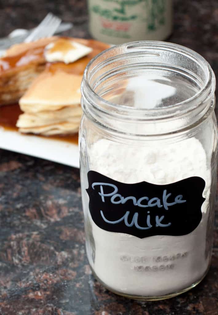 a jar of pancake mix with pancakes in the background